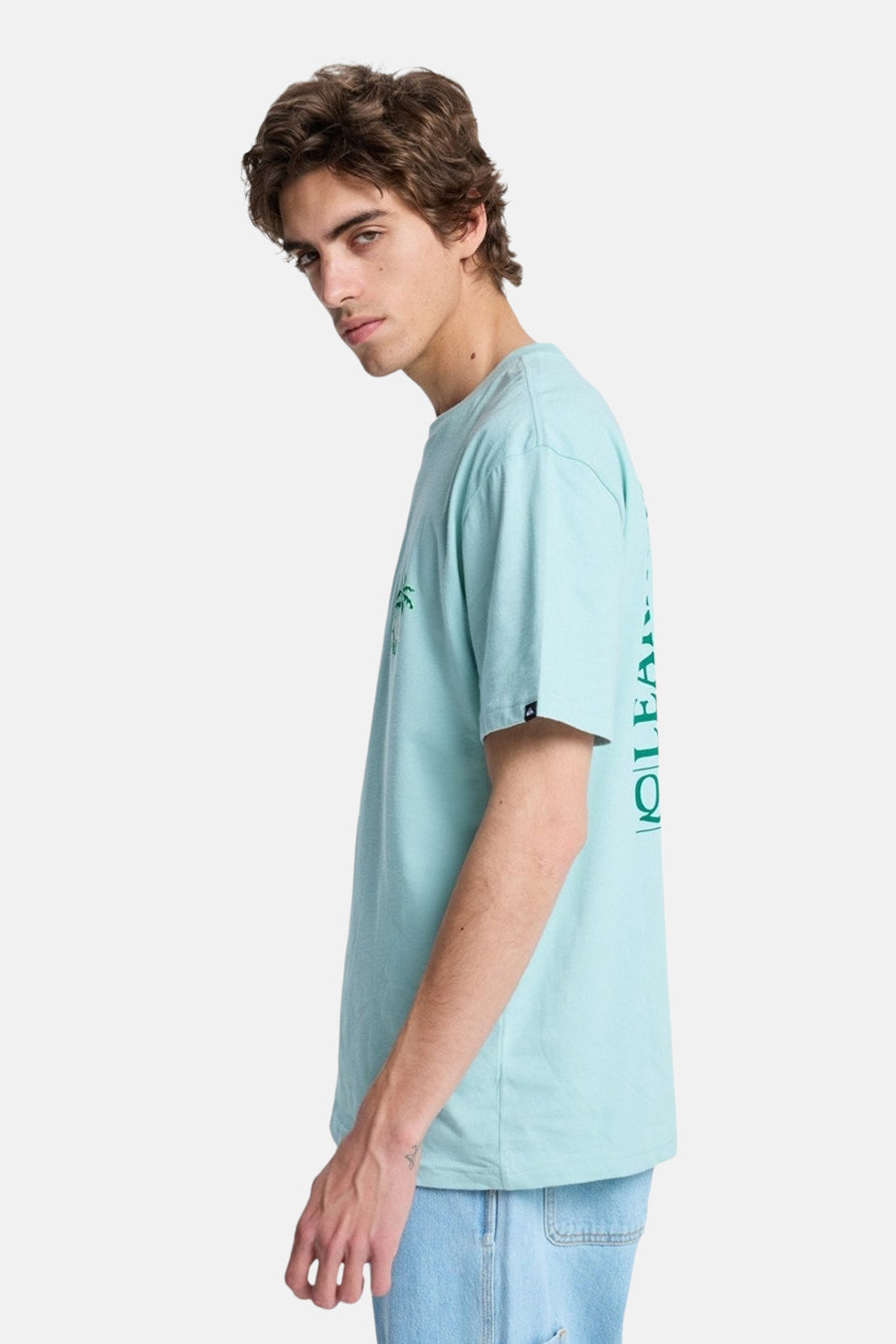 Blauw T-shirt van Quiksilver, met korte mouwen en een kleine palmbomenprint, te zien in zijaanzicht.