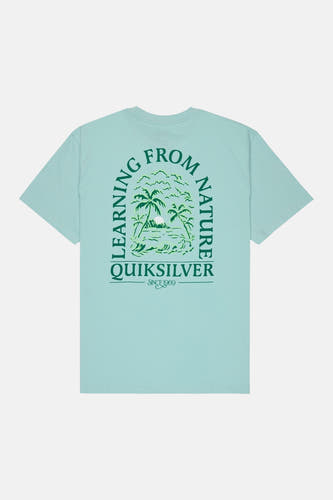 T-shirt bleu Quiksilver avec imprimé vert "Learning from Nature" avec des palmiers dans le dos.