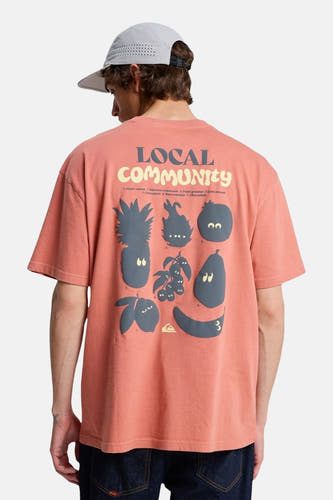 T-shirt rouge à manches courtes de Quiksilver, avec un imprimé graphique, porté avec une casquette et un jean foncé.