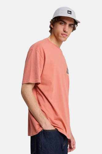 Rood T-shirt met korte mouwen van Quiksilver, met een grafische print, gedragen met een pet en donkere jeans.
