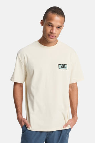 T-shirt écru à manches courtes Quiksilver, avec un logo sur la poitrine et un pantalon bleu.