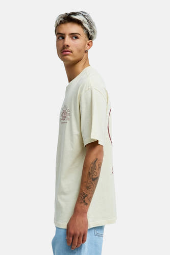 Ecru T-shirt van Quiksilver, met korte mouwen en printdetails, gezien vanaf de zijkant.