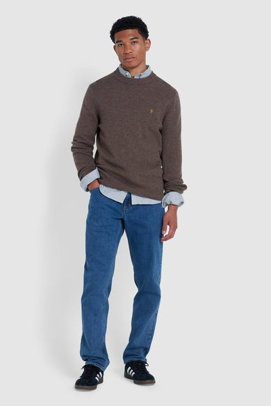 Pull marron avec col rond de FARAH, porté sur une chemise bleue claire à manches longues et des jeans bleus.