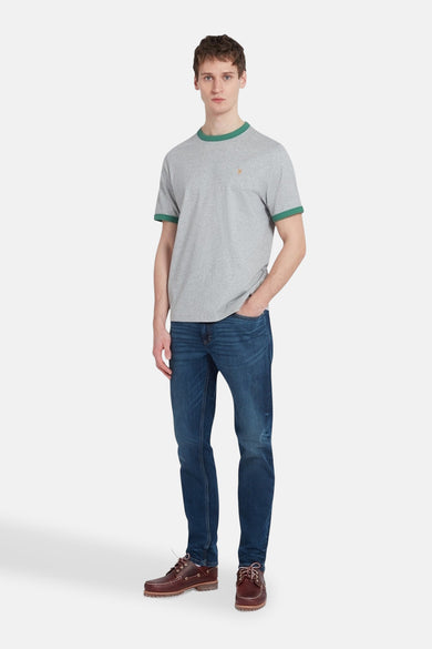 Grijs T-shirt met korte mouwen van FARAH, met groene randen langs de hals en mouwen, gedragen met donkere jeans en bruine boots.
