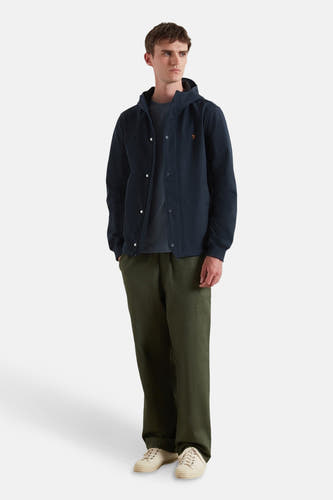 Manteau court bleu de FARAH, avec capuche, boutons-pression et pantalon olive.