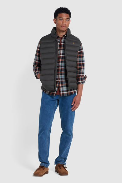 Chemise multicolore à manches longues de FARAH, portée avec un bodywarmer gris foncé, des jeans bleus et des chaussures brunes.