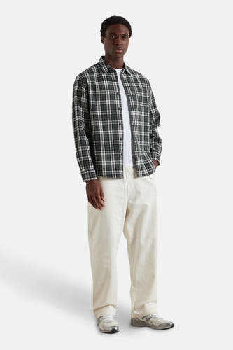 Chemise multicolore à manches longues de Farah, avec un motif à carreaux, portée sur un T-shirt blanc et des pantalons crème.
