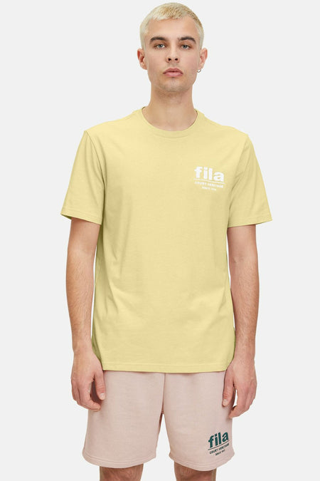 T-shirt jaune à manches courtes de FILA, vu de derrière, porté avec des short roses.