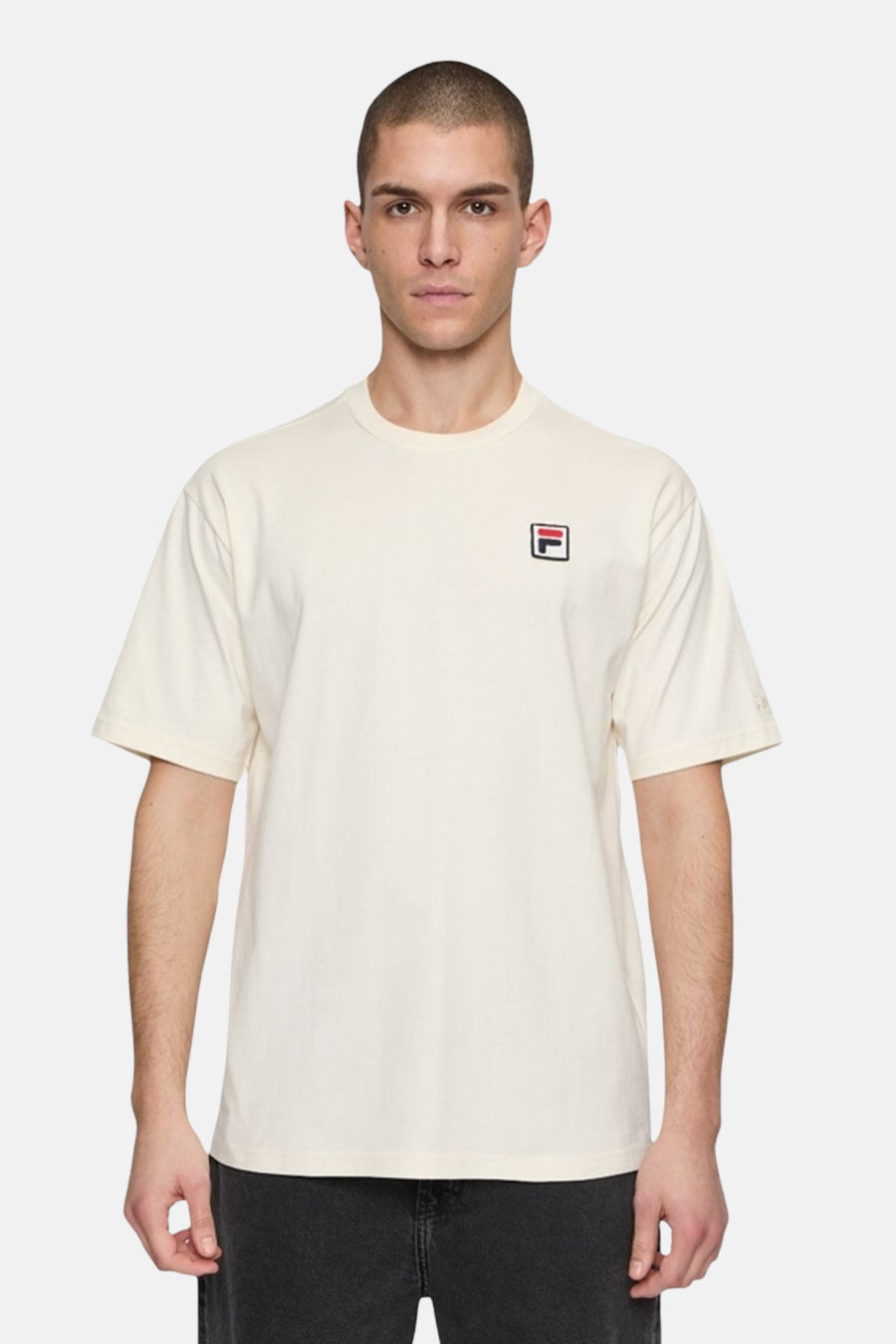 T-shirt écru à manches courtes de FILA, avec logo sur la poitrine et porté par un homme.
