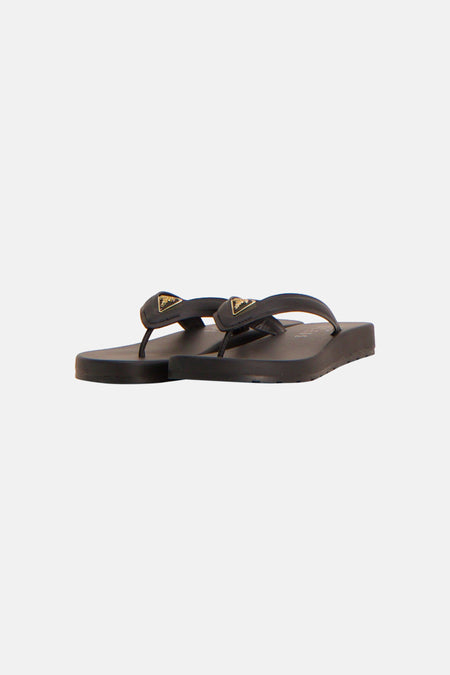 Tongs noirs Guess avec un détail doré sur la bride, vus de dos.