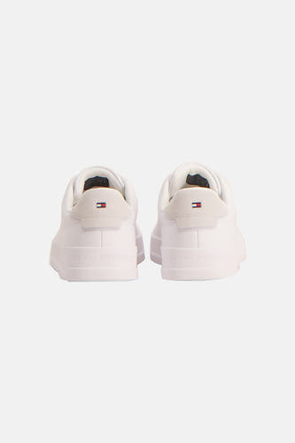 Sneakers blanches de TOMMY JEANS, avec des accents en suède à l'arrière et le nom de la marque sur la semelle.