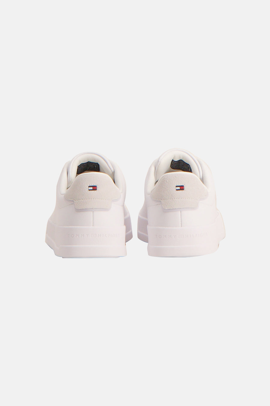 Sneakers blanches de TOMMY JEANS, avec des accents en suède à l'arrière et le nom de la marque sur la semelle.