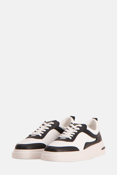 Sneakers noirs de Guess avec des lacets blancs et une semelle épaisse.