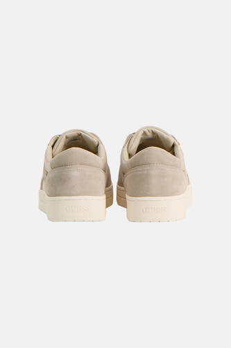 Baskets beiges de Guess avec texture effet daim et 'GUESS' en relief sur le talon, face arrière visible.