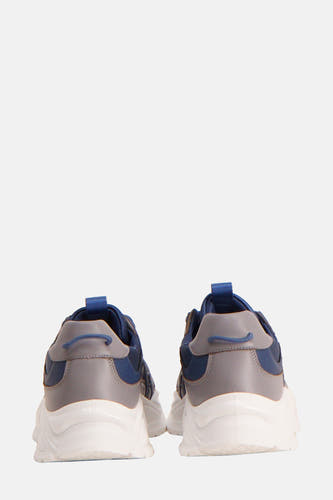 Sneakers bleues de Guess®, vus de l'arrière, avec des accents gris et une semelle blanche épaisse.
