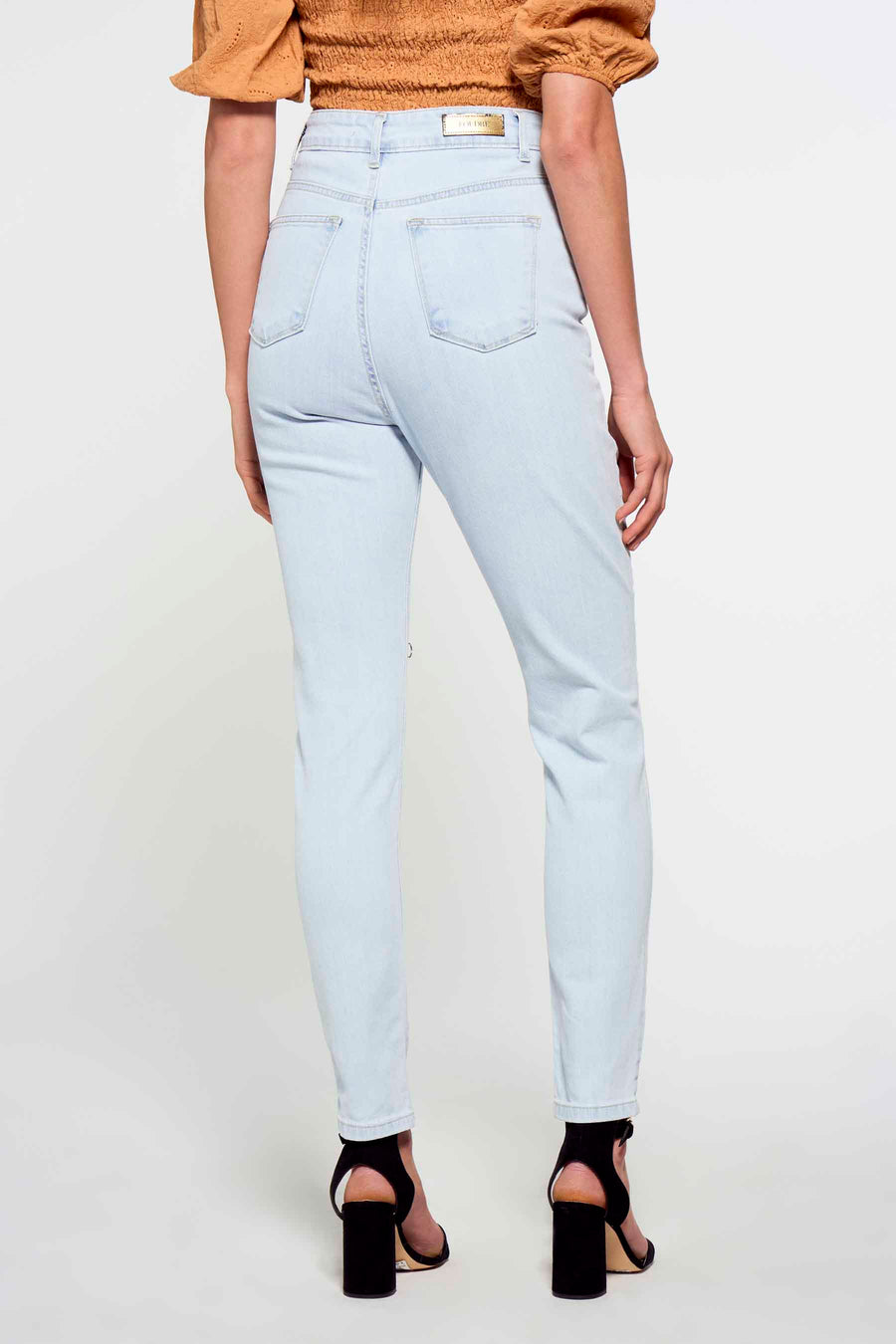 Jean slim fit bleu clair en denim de FOUDRE by Aurélie Van Daelen, avec taille haute et dos visible.