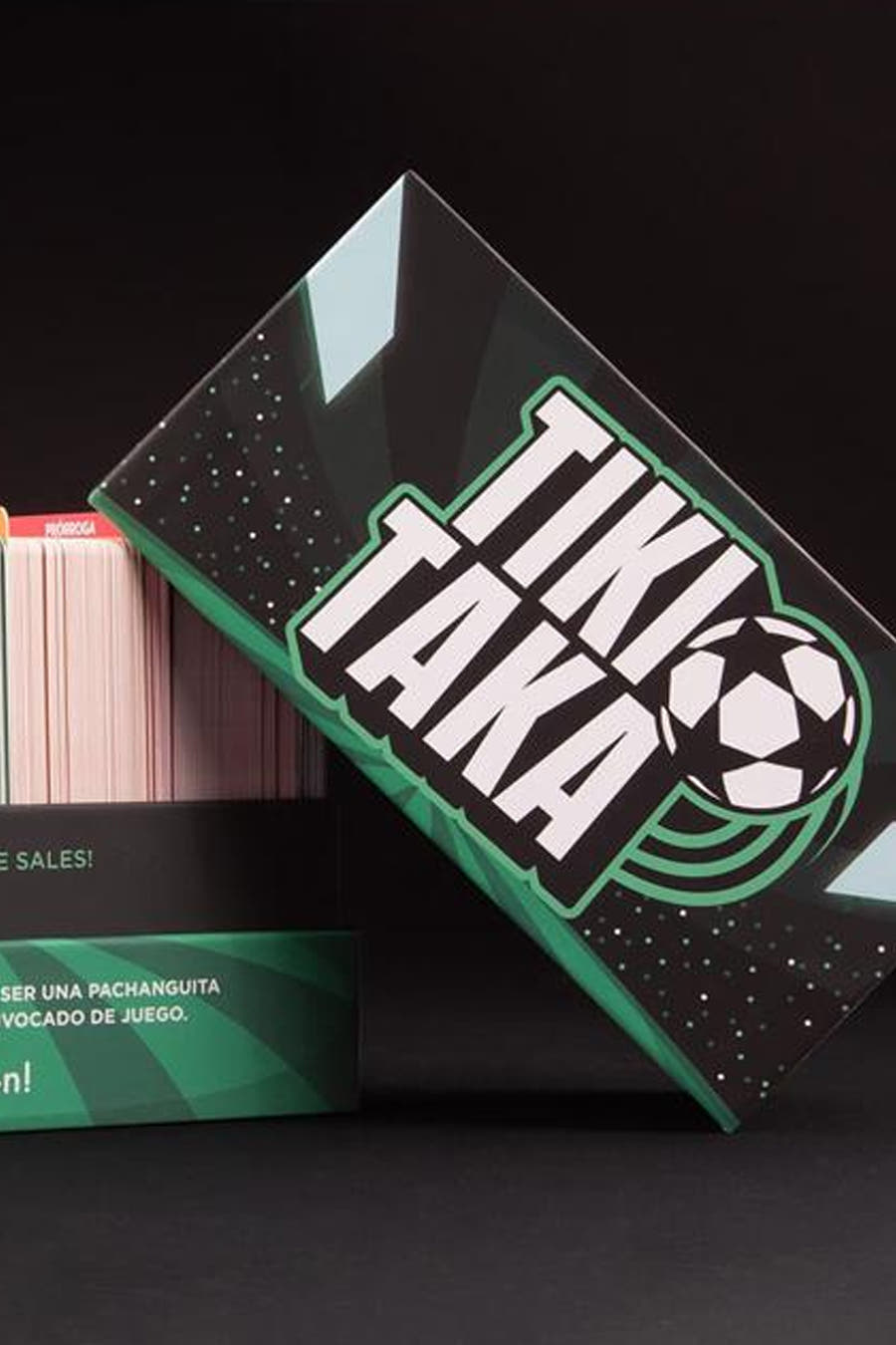 Jeu multicolore TIKI TAKA d'HELLOFUN, avec la boîte penchée et des cartes en arrière-plan.
