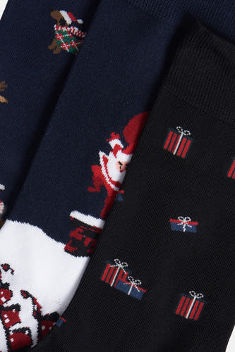 Chaussettes multicolores de FunSocks avec des designs thématiques de Noël, notamment un Père Noël, un cadeau et un chien.