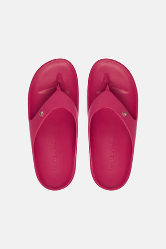 Tongs roses TOMMY JEANS avec un petit logo sur la bride et le nom de la marque en relief sur la semelle intérieure, vus de dessus.