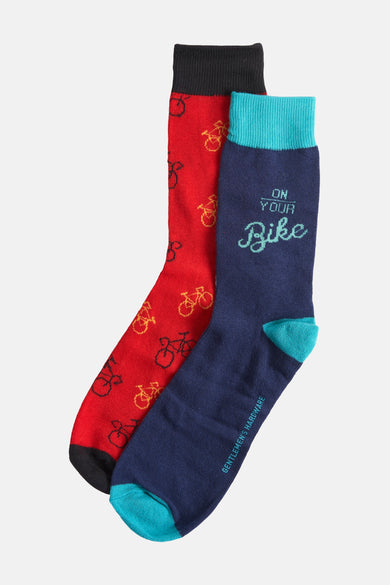 Boutiques de cadeaux multicolores de Gentlemen's Hardware, avec des chaussettes rouges à motif de vélo et des chaussettes bleues avec le texte "On Your Bike".