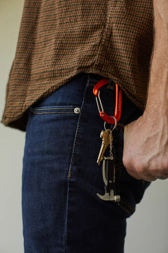 Cadeau multicolore de Gentlemen's Hardware, fixé à un jean bleu marine avec une mousqueton orange.