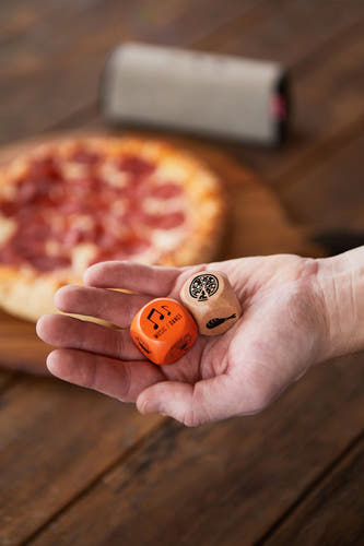Lot de dés coloré 'cadeau' de Gentlemen's Hardware, avec une pizza et un haut-parleur sur une table en bois.