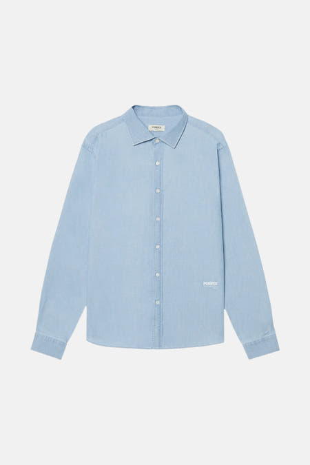 Chemise en denim bleu clair de POMPEII, avec des boutons blancs et un col.