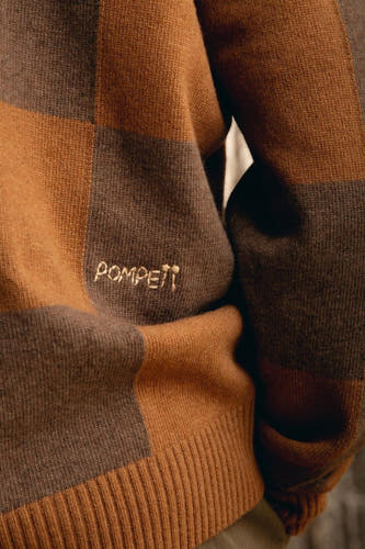 Gilet brun de POMPEII avec un motif à carreaux et le nom de la marque brodé sur l'avant.