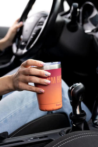 Cadeau multicolore de FISURA, maintenu dans l'intérieur d'une voiture à côté d'un levier de vitesse.