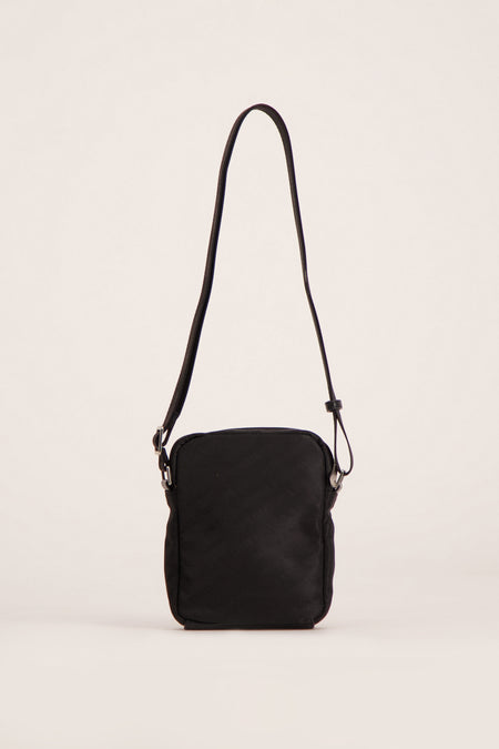 Sac à dos noir de Guess, avec une sangle d'épaule ajustable et des détails argentés.