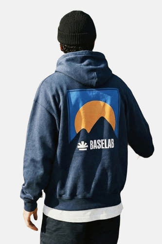 Blauwe sweater met kap van BASELAB, met een afbeelding van een berg en de zon op de rug.