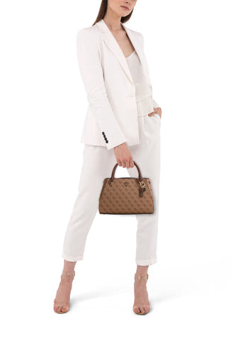 Sac à main marron de Guess avec un motif monogramme, porté par un modèle en pantalon blanc et blazer.