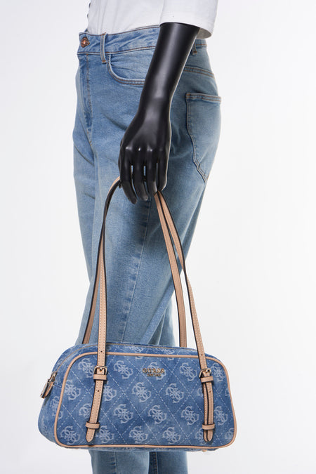 Sac en cuir de denim bleu Guess, avec imprimé logo sur toute la surface et détails beige, associé à un jean et une chemise blanche.