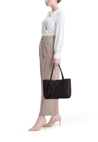 Sac à dos noir de Guess avec un cintre, associé à une blouse blanche et un pantalon beige et des escarpins.