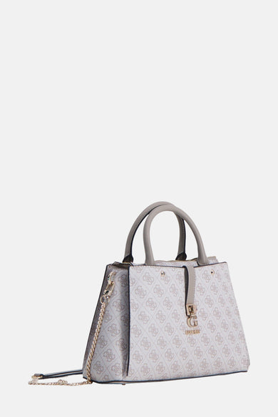 Sac à main beige de Guess, avec un motif et des détails dorés, porté avec un jean brut et une chemise blanche.