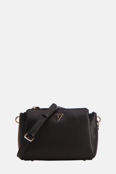 Sac à main noir de Guess, avec logo or et accents en chaîne, porté avec un blazer blanc et une chemise.