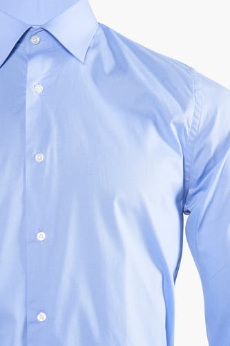 Chemise bleue à manches longues de Le Fabuleux Marcel de Bruxelles, avec col et boutons, gros plan.