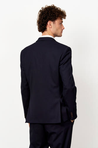 Blazer bleu de Le Fabuleux Marcel de Bruxelles, avec une chemise et un vest-shirt blanc.