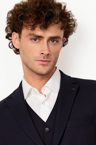 Blazer bleu de Le Fabuleux Marcel de Bruxelles, avec une chemise blanche et un pantalon bleu marine.