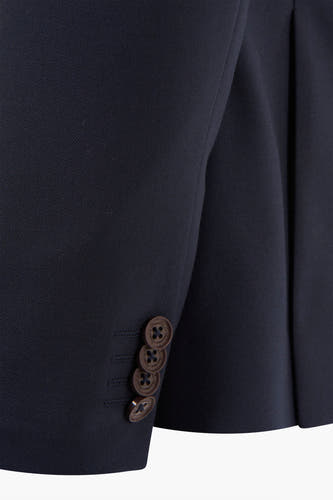 Blazer bleu de Le Fabuleux Marcel de Bruxelles, avec des boutons bruns sur les manches, en gros plan.
