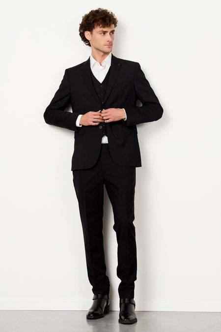 Zwarte kostuumbroek van Le Fabuleux Marcel de Bruxelles, gedragen met een wit overhemd en een zwart gilet.