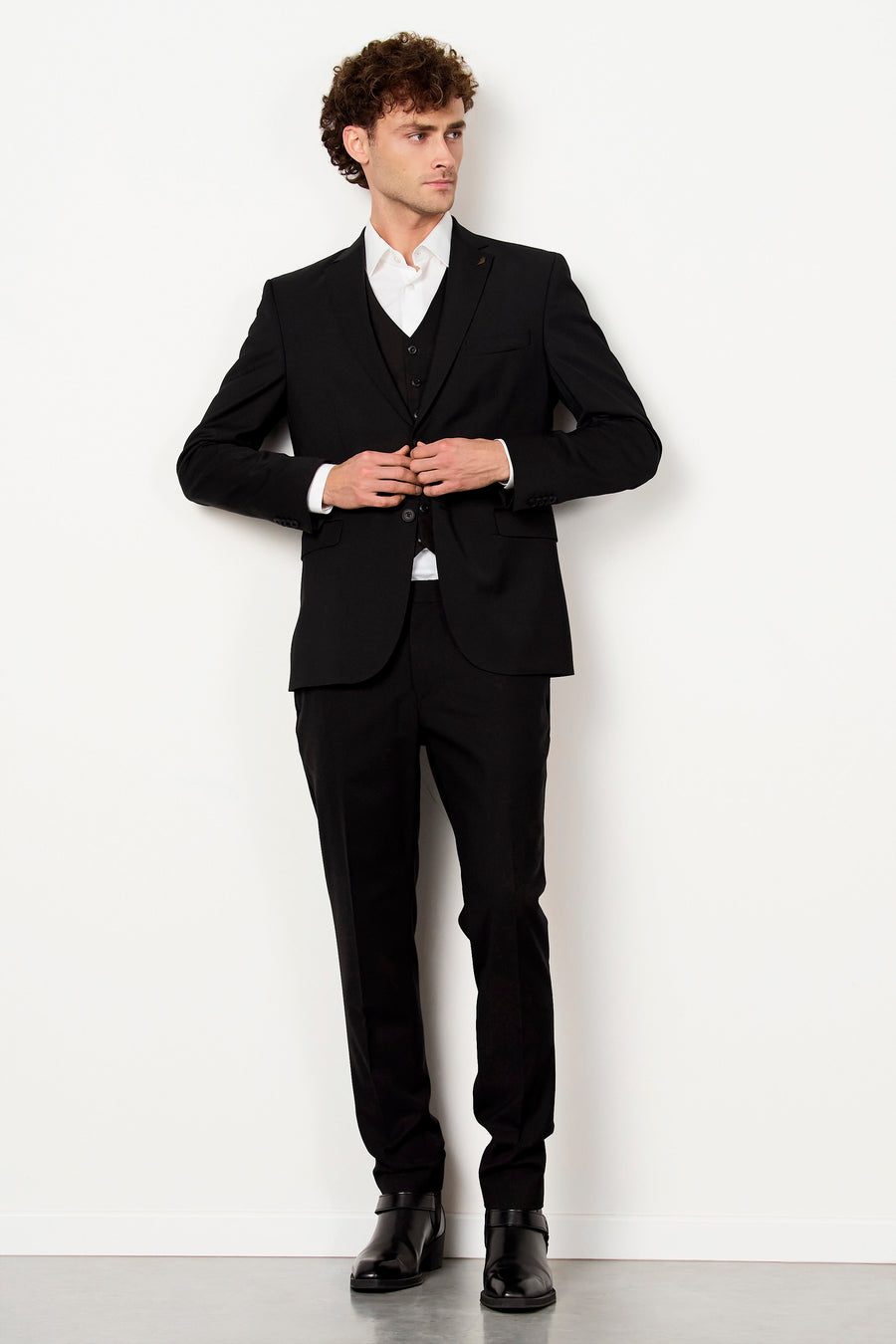 Pantalon de costume noir de Le Fabuleux Marcel de Bruxelles, porté par un homme avec un costume noir et une chemise blanche.
