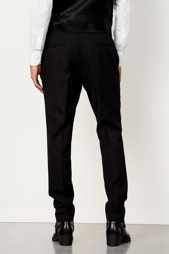 Pantalon de costume noir de Le Fabuleux Marcel de Bruxelles avec poches passepoilées, stylisé avec une chemise blanche, un gilet noir et des bottes noires, vue arrière.