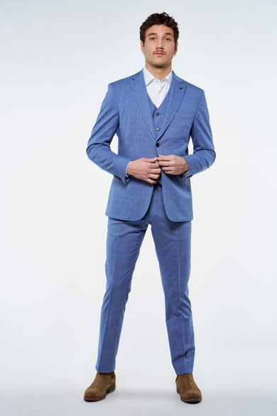 Blazer bleu de Le Fabuleux Marcel de Bruxelles, avec une subtile rayure, porté sur un chemise blanc et un gilet coordonné.