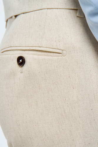 Pantalon de costume beige Le Le Fabux Marcel de Bruxelles, avec un texture motif et et un bouton sur la poche arrière.