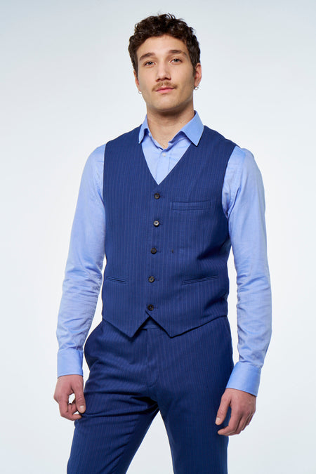Gilet bleu à rayures craie de Le Fabuleux Marcel de Bruxelles, dos avec boucle réglable, porté sur une chemise bleu clair et un pantalon assorti.