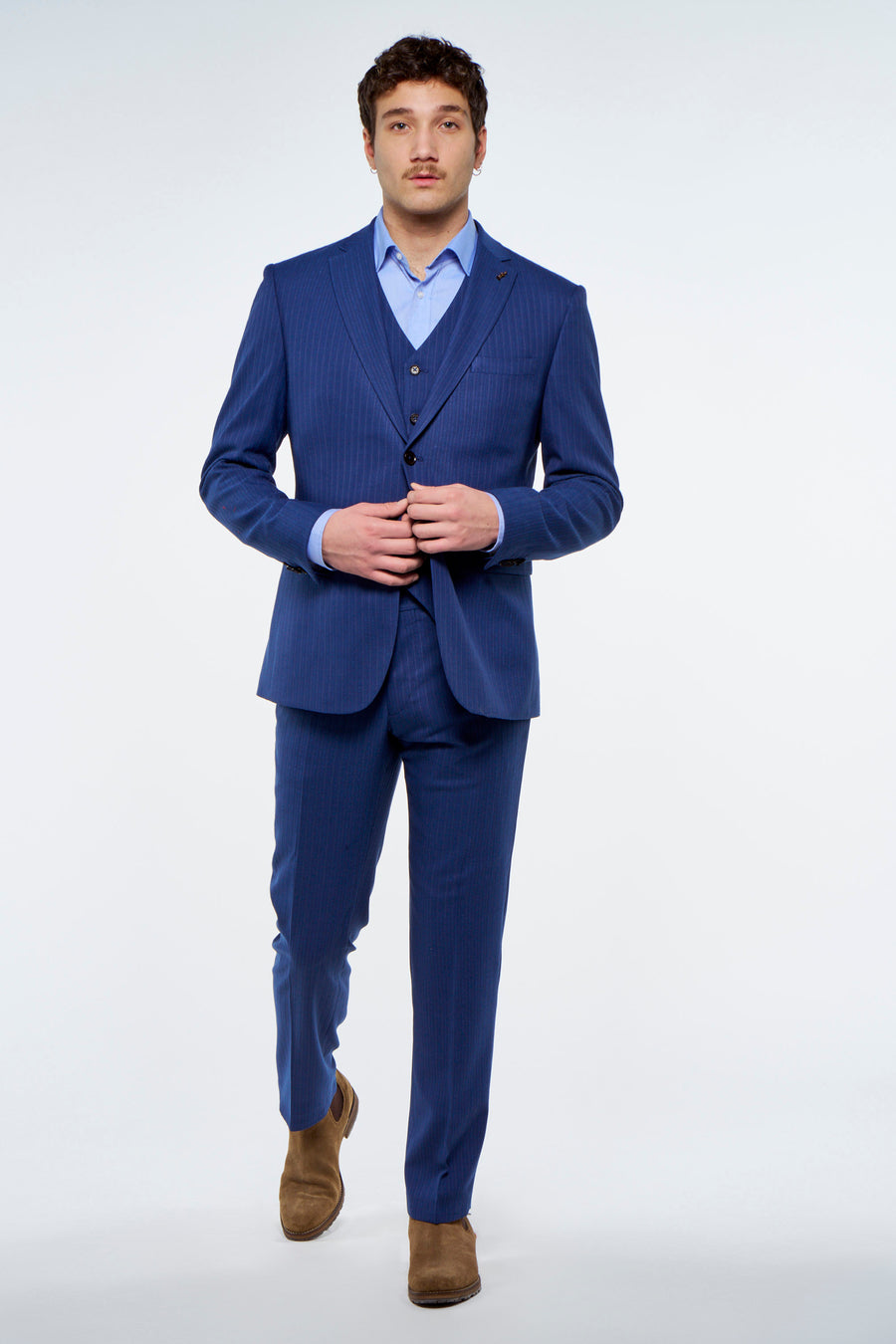 Gilet bleu de Le Fabuleux Marcel de Bruxelles avec rayures craie et trois boutons, porté dans le cadre d'un costume.