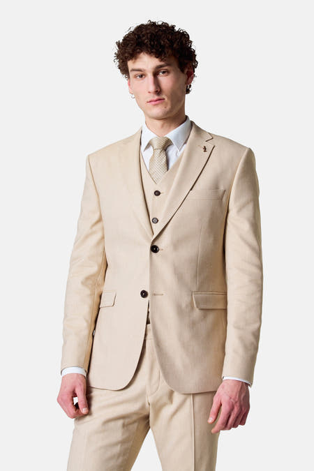 Blazer beige de Le Fabuleux Marcel de Bruxelles, combiné avec une chemise et un nœud papillon.