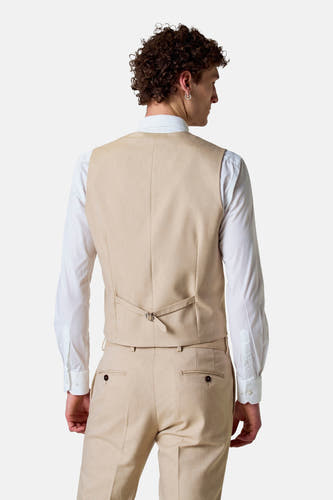 Beige gilet van Le Fabuleux Marcel de Bruxelles, gezien van achteren, gedragen over een wit overhemd en bijpassende pantalon.