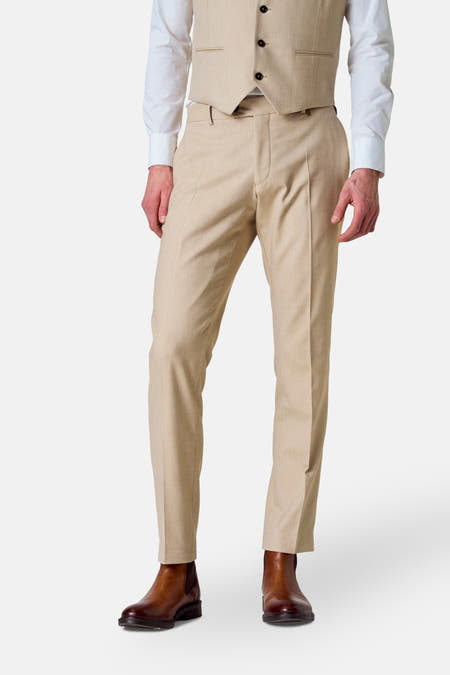 Pantalon costumé beige de Le Fabuleux Marcel de Bruxelles, vu de derrière, associé à des chaussures brunes et à une chemise blanche.